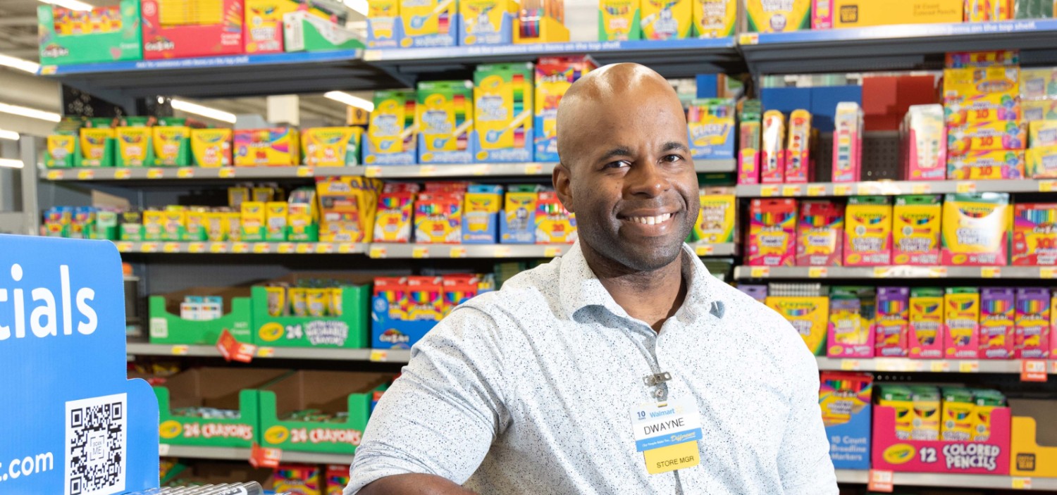 Male associate in front of a Walmart aisle